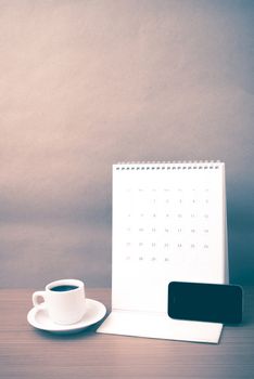 coffee cup and phone and calendar on wood background vintage style