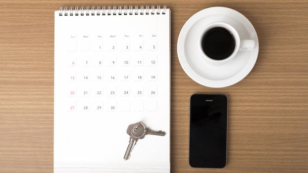 coffee,phone,key and calendar on wood table background