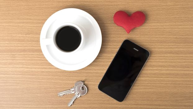 coffee phone key and heart on wood table background