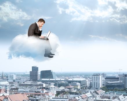 Sad businessman working on laptop and sitting on cloud above city