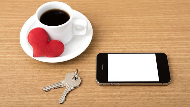 coffee phone key and heart on wood table background