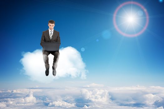 Businessman working on laptop and sitting on cloud in sky