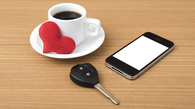 coffee phone car key and heart on wood table background