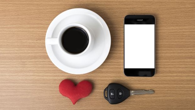 coffee phone car key and heart on wood table background