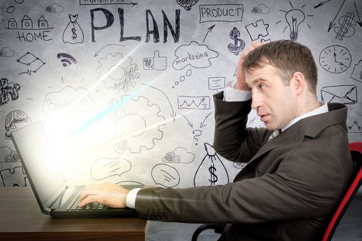 Thinking businessman working on glowing laptop grey wall background with different symbols