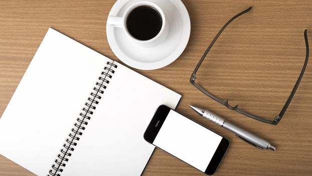 coffee,phone,notepad and eyeglasses on wood table background