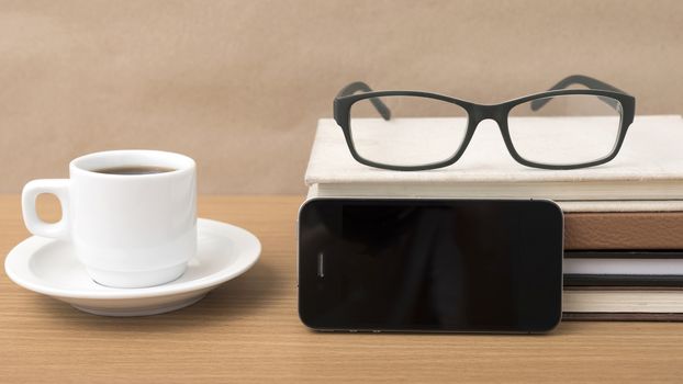 coffee,phone,stack of book and eyeglasses on wood table background