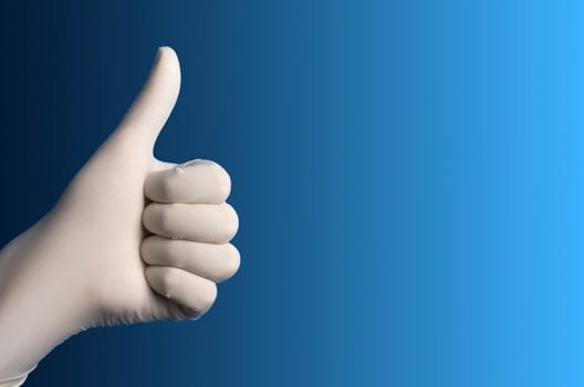 Hand with a white surgical glove showing the ok sign against a blue background