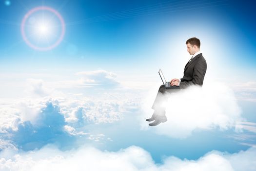 Businessman working on laptop and sitting on cloud in sky