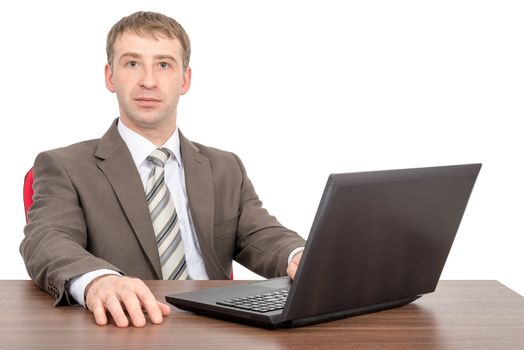 Businessman working on laptop and looking at camera isolated on white background