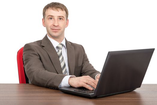 Smiling businessman working on laptop and looking at camera isolated on white background