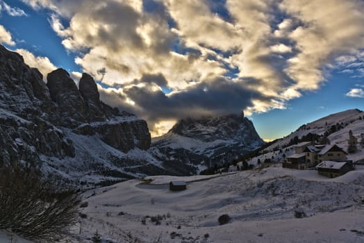 Winter landscape from Gardena Pass in the Dolomites at the sunset with clouds over the top, Italian mountains - Trentino Alto-Adige, italy