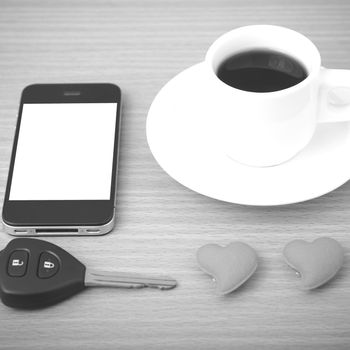 coffee phone car key and heart on wood table background black and white color