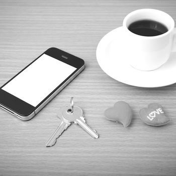 coffee phone key and heart on wood table background black and white color