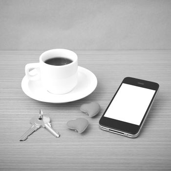 coffee phone key and heart on wood table background black and white color