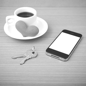 coffee phone key and heart on wood table background black and white color