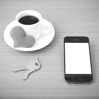 coffee phone key and heart on wood table background black and white color