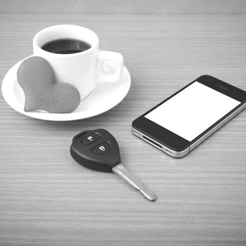 coffee phone car key and heart on wood table background black and white color