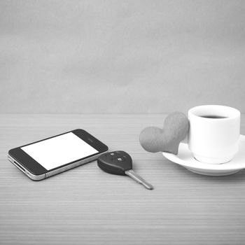 coffee phone car key and heart on wood table background black and white color