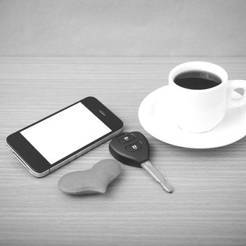 coffee phone car key and heart on wood table background black and white color