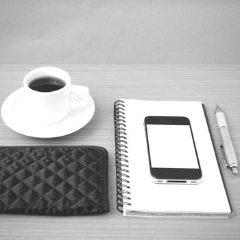 coffee,phone,notepad and wallet on wood table background black and white color