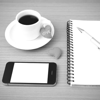 coffee,phone,notepad and heart on wood table background black  and white color