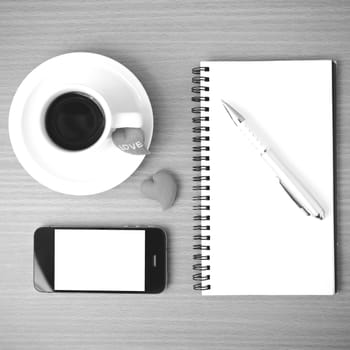 coffee,phone,notepad and heart on wood table background black  and white color