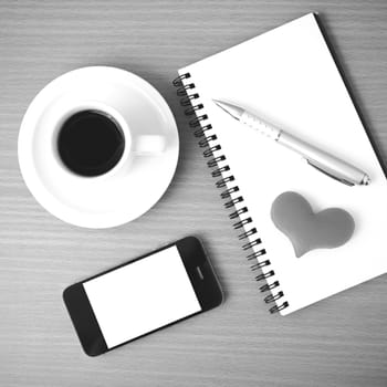 coffee,phone,notepad and heart on wood table background black  and white color