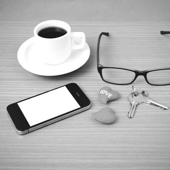 coffee,phone,eyeglasses,key and heart on wood table background black  and white color