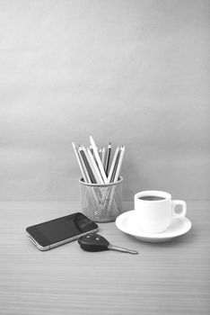 coffee,phone,car key and heart on wood table background black and white color