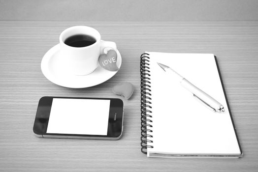 coffee,phone,notepad and heart on wood table background black  and white color