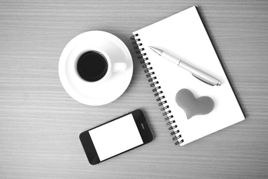 coffee,phone,notepad and heart on wood table background black  and white color