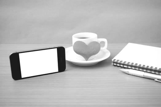 coffee,phone,notepad and heart on wood table background black  and white color