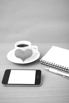 coffee,phone,notepad and heart on wood table background black  and white color