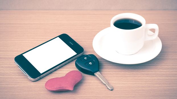 coffee phone car key and heart on wood table background vintage style
