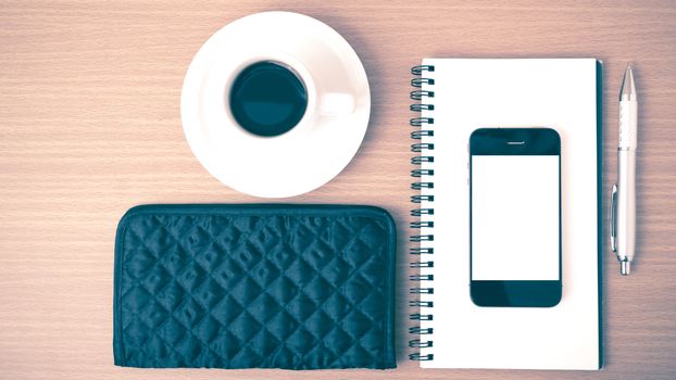 coffee,phone,notepad and wallet on wood table background vintage style