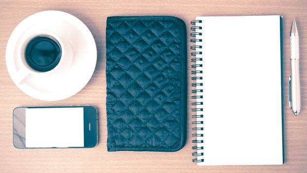 coffee,phone,notepad and wallet on wood table background vintage style