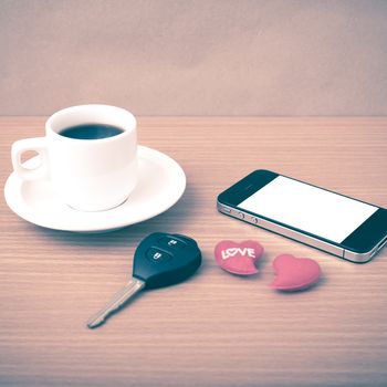 coffee phone car key and heart on wood table background vintage style