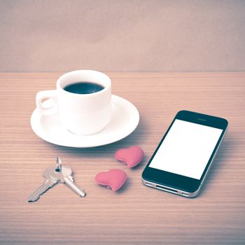 coffee phone key and heart on wood table background vintage style