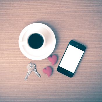 coffee phone key and heart on wood table background vintage style