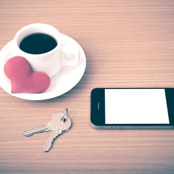 coffee phone key and heart on wood table background vintage style