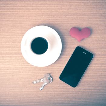 coffee phone key and heart on wood table background vintage style