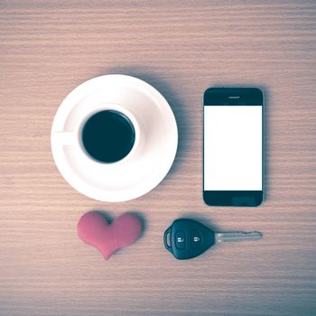 coffee phone car key and heart on wood table background vintage style