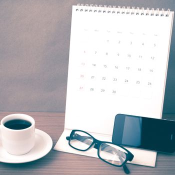 coffee,phone,eyeglasses and calendar on wood table background vintage style