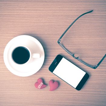 coffee,phone,eyeglasses and heart on wood table background vintage style