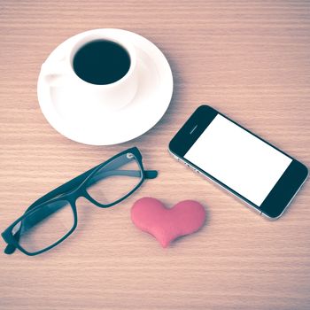 coffee,phone,eyeglasses and heart on wood table background vintage style