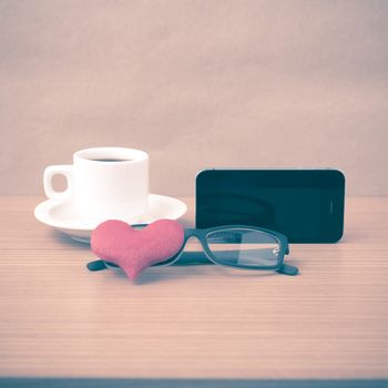 coffee,phone,eyeglasses and heart on wood table background vintage style