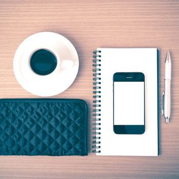 coffee,phone,notepad and wallet on wood table background vintage style