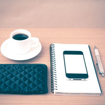 coffee,phone,notepad and wallet on wood table background vintage style