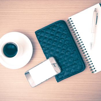 coffee,phone,notepad and wallet on wood table background vintage style